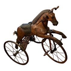 a statue of a horse is riding on an old fashioned tricycle with no wheels