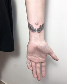 a person's arm with an angel tattoo on the left side of their hand