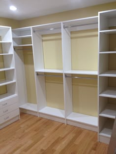 an empty walk in closet with white shelving and wood flooring on the hard wood floor