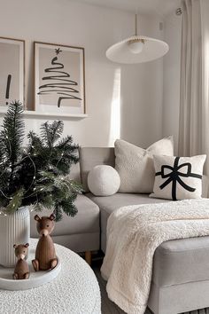 a living room filled with white furniture and christmas decorations on top of a coffee table