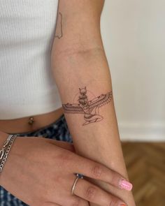 a woman's arm with a small tattoo on the left side of her arm