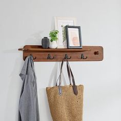 a coat rack with two coats hanging from it and a purse on the wall next to it