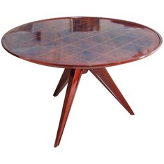 a round table with wooden legs and a glass top