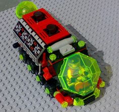 a toy truck with lights and wheels on top of a lego flooring area that looks like it is made out of legos