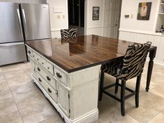 a large kitchen island with zebra print chairs