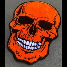 an orange and black patch with a smiling skull on it's back side,