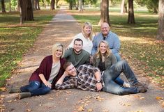 a group of people sitting on the ground in front of trees