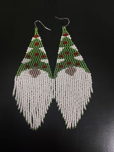 beaded christmas tree earrings on a black surface