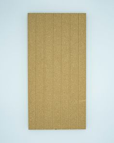 a brown piece of cardboard sitting on top of a white floor next to a wall