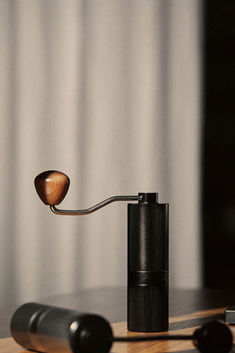 a wooden spoon sitting on top of a table next to a black pepper grinder