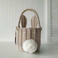 a white pom - pom in a wicker basket