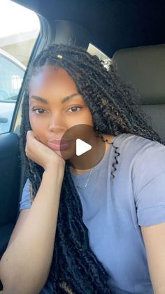 a woman sitting in the back seat of a car with her hand on her chin