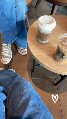 a person sitting at a table with a cup of coffee in front of them on their lap