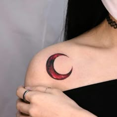 a woman with a crescent tattoo on her shoulder