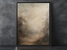 a painting hanging on the wall in front of a concrete wall with a black frame