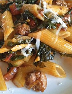 pasta with meat, spinach and cheese on a white plate