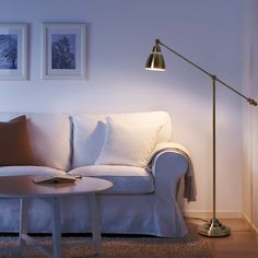 a living room with a white couch and two pictures on the wall