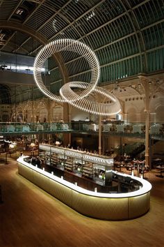 the interior of a restaurant with lights and circular chandelier hanging from the ceiling