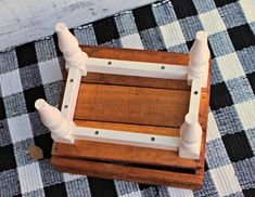 a wooden box with white handles on a black and white checkered tablecloth area