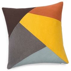 an orange, brown and yellow pillow with geometric designs on it's back side