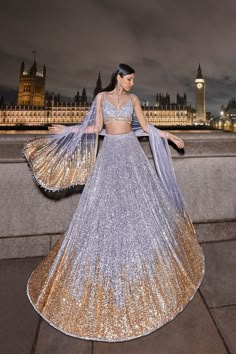 a woman in a blue and gold lehenga with big ben in the background