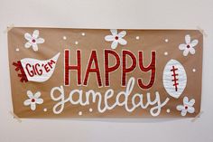 a paper sign that says happy gameday hanging on the wall in front of a white wall