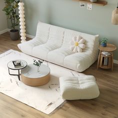 a living room filled with furniture and a flower decoration on the wall above the couch