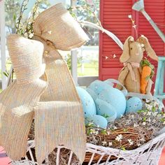 a basket filled with easter eggs and a stuffed bunny sitting next to it on top of a table