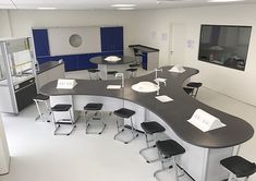 an empty office with desks and stools in the center, including two chairs