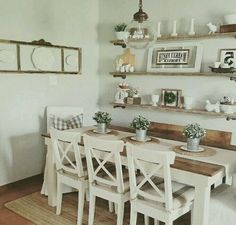 the dining room table is set with four chairs, and there are pictures on the wall above it