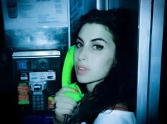 a woman holding a green banana in her hand