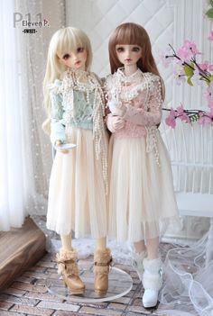 two dolls are standing next to each other