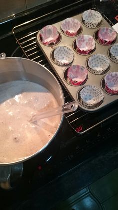 a pan filled with cupcake batter sitting on top of an oven