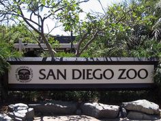 there is a sign that says san diego zoo in front of some rocks and trees