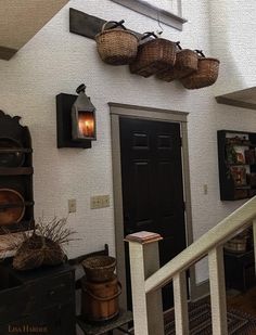 an entry way with baskets hanging on the wall and stairs leading up to another room