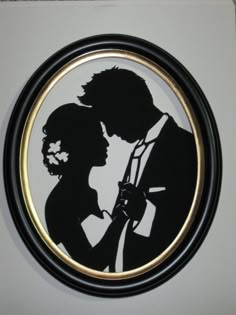 a couple is silhouetted in a black and white circle with gold trim around the edges