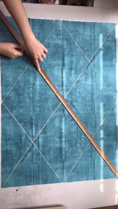 someone is measuring the length of a blue rug