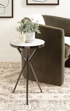 a small table with a potted plant sitting on it in front of a couch