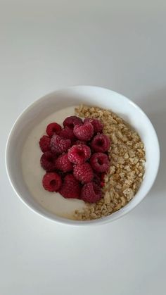 a bowl filled with oatmeal and raspberries on top of it