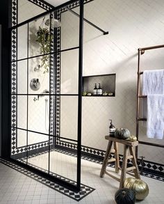 a black and white tiled bathroom with an open shower