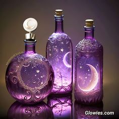 three purple bottles with designs on them are sitting next to each other in front of a black background