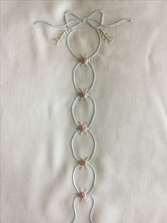 a close up of a piece of cloth with beads and flowers on the end of it