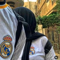 the back of a person wearing a backpack with real madrid crests on it's side