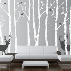 a living room with white couches and wall decals on the walls in front of it