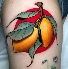 an orange tattoo on the thigh with leaves