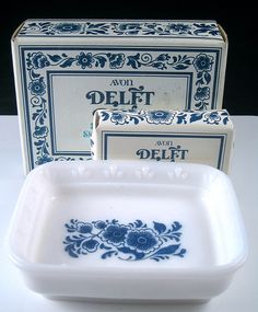 two blue and white dishes sitting on top of a table next to a box that says delft