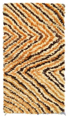 an orange, brown and black area rug on a white background with diagonal lines in the middle