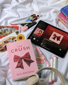 various books, pens and headphones on a bed