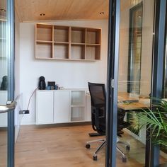 an office with glass walls and wooden floors