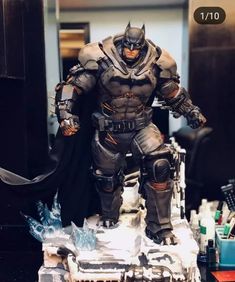 the batman statue is on display in front of some other items, including a bat